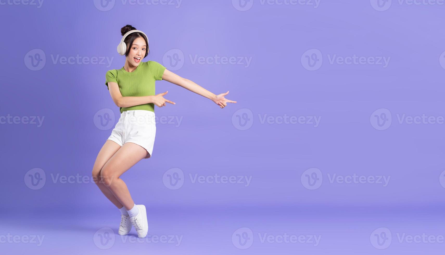 full body image of beautiful asian girl posing on pink background photo