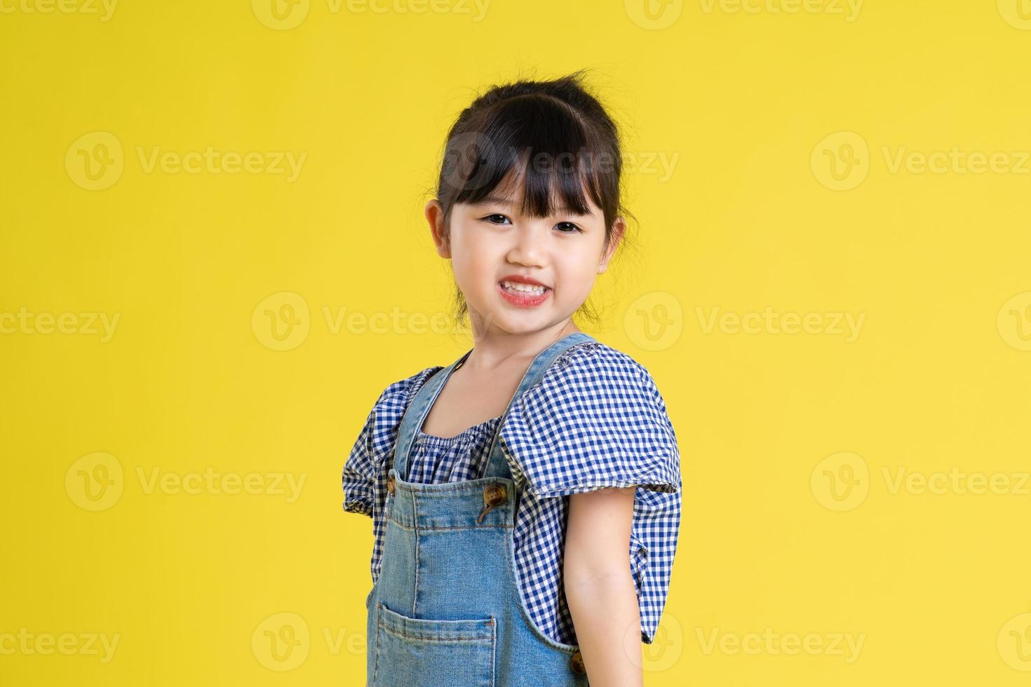 portrait of a beautiful asian girl, isolated on yellow background photo