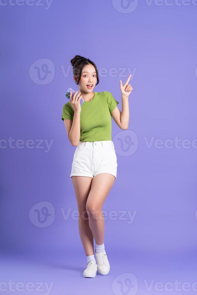 full body image of beautiful asian girl posing on pink background photo
