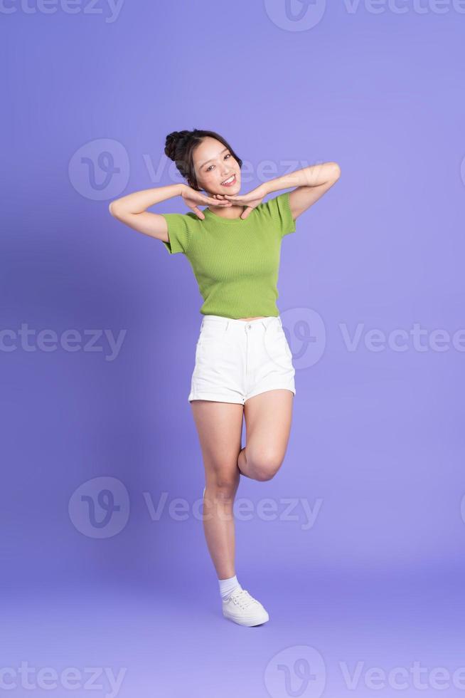 full body image of beautiful asian girl posing on pink background photo