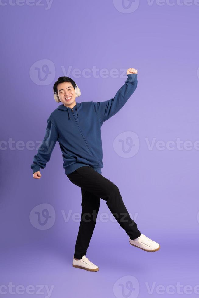 portrait of asian man posing on purple background photo