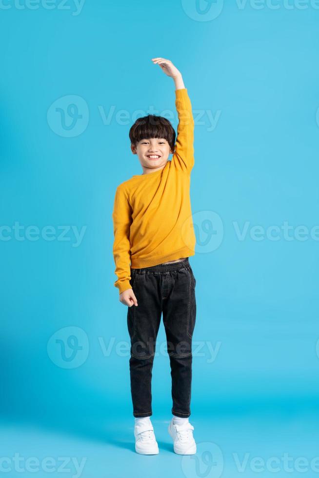 full body image of asian boy posing on blue background photo