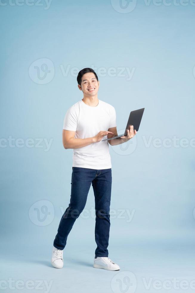portrait of asian man posing on blue background photo