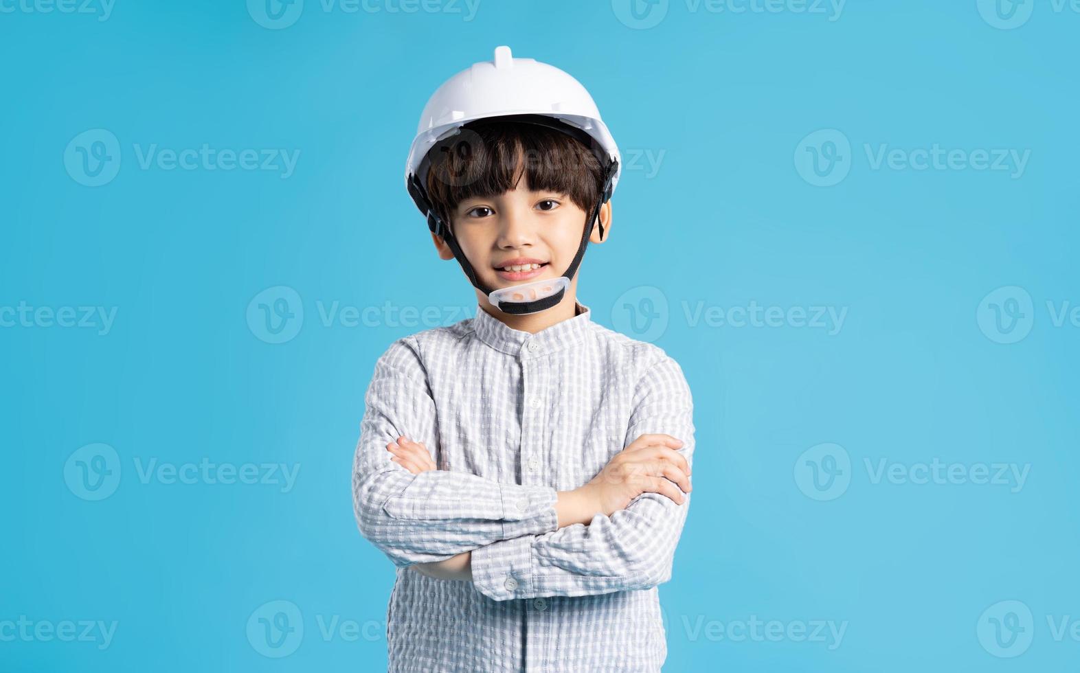 asiático chico retrato jugando el papel de un ingeniero, aislado en azul antecedentes foto