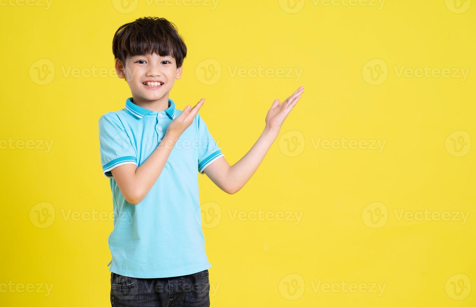 portrait of an asian boy posing on a yellow background photo