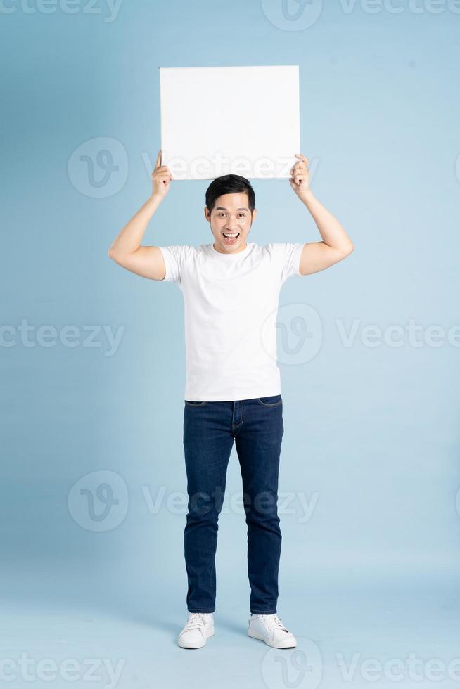 portrait of asian man posing on blue background photo