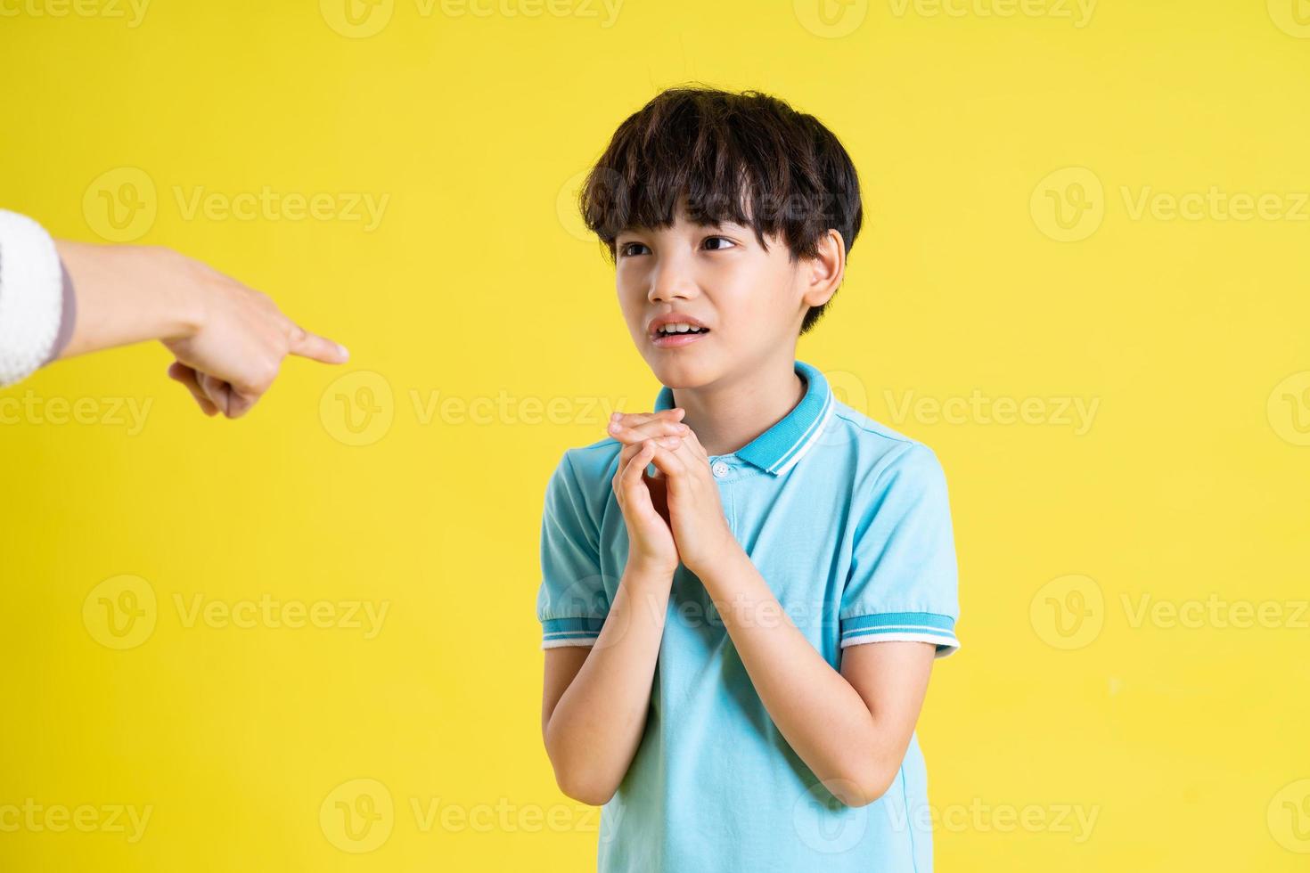 portrait of an asian boy posing on a yellow background photo