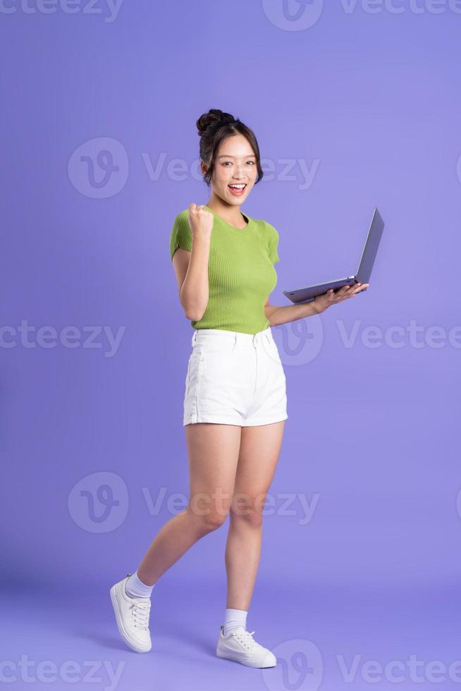 full body image of beautiful asian girl posing on pink background photo