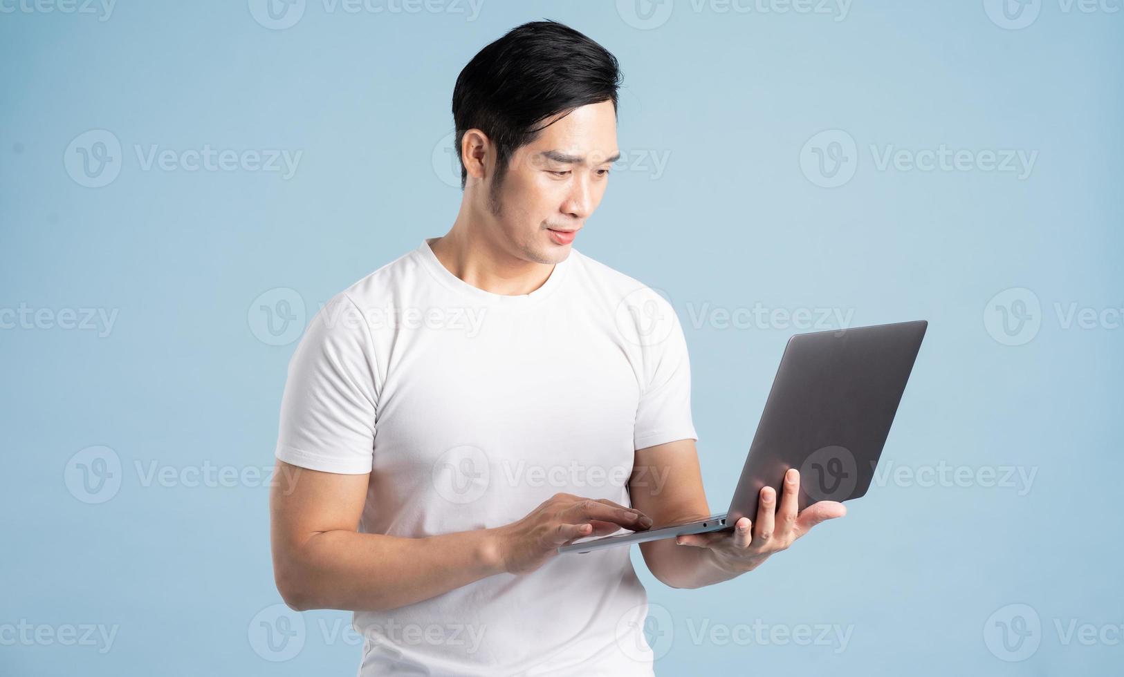 portrait of asian man posing on blue background photo