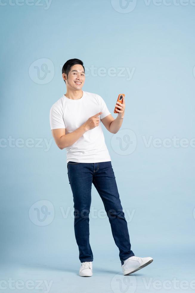 portrait of asian man posing on blue background photo