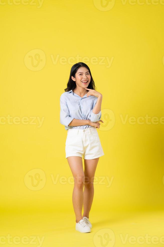 full body image of beautiful asian girl, isolated on yellow background photo
