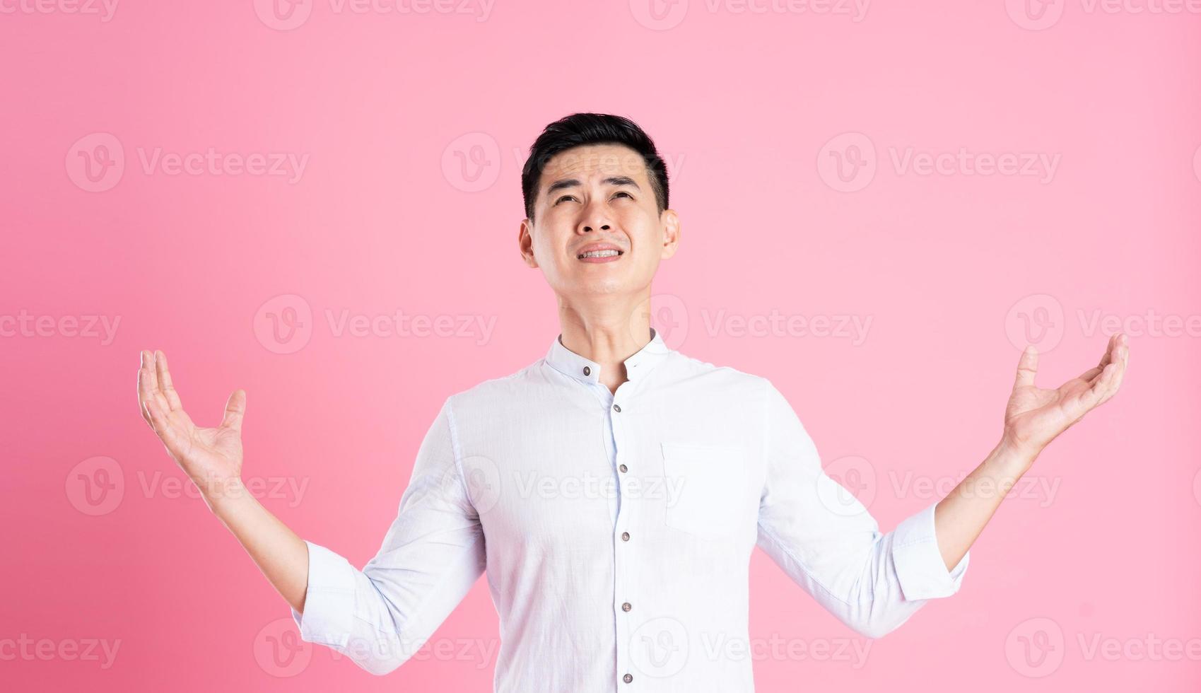 portrait of asian man posing on pink background photo