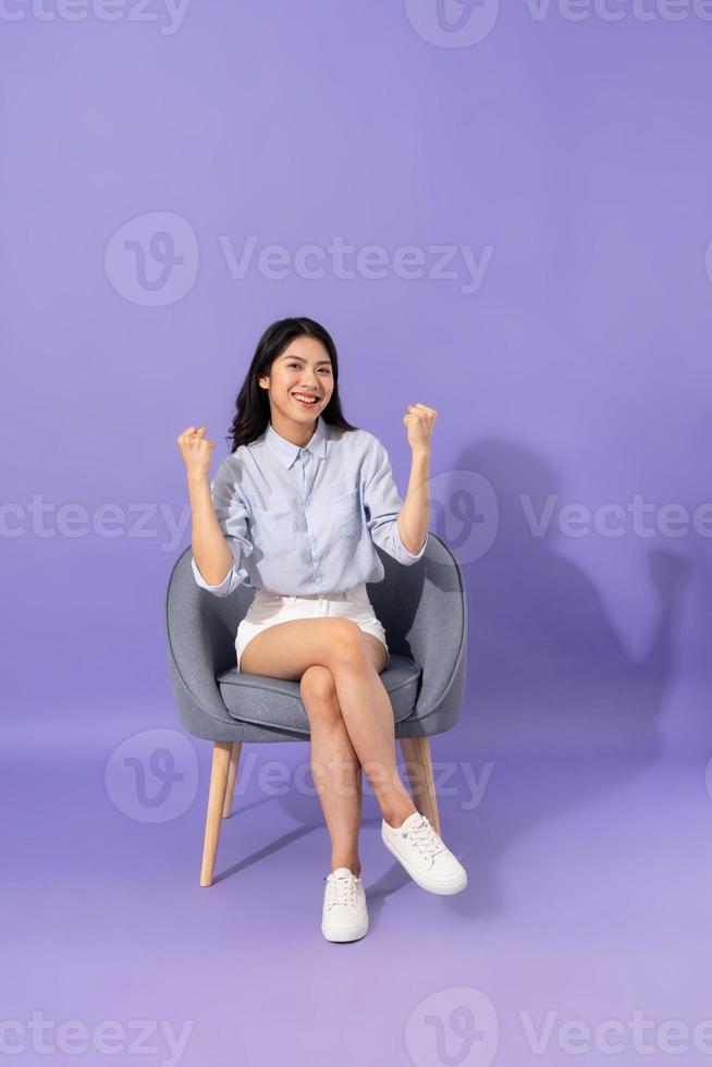 image of girl sitting on sofa  isolated on purple background photo