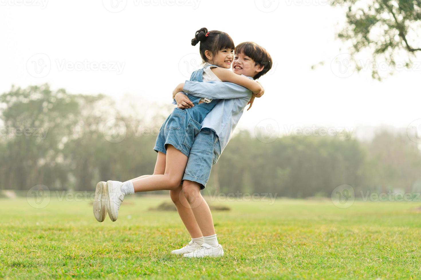 image of brother and sister having fun in the park photo