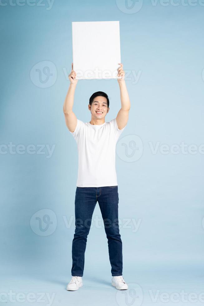 portrait of asian man posing on blue background photo