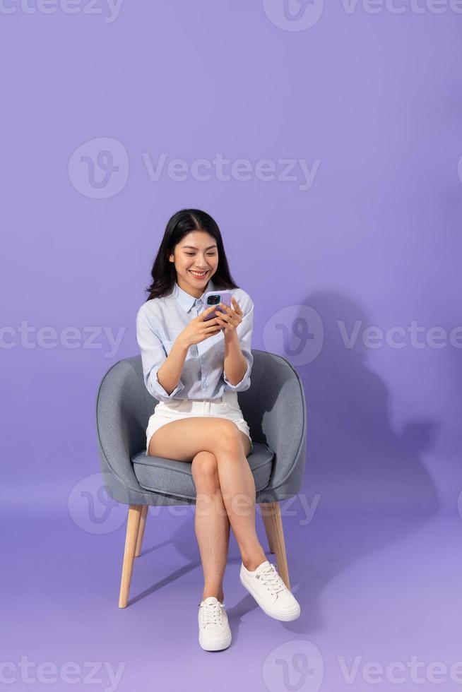image of girl sitting on sofa  isolated on purple background photo