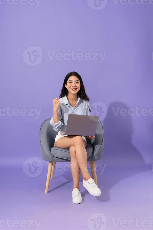 image of girl sitting on sofa  isolated on purple background photo