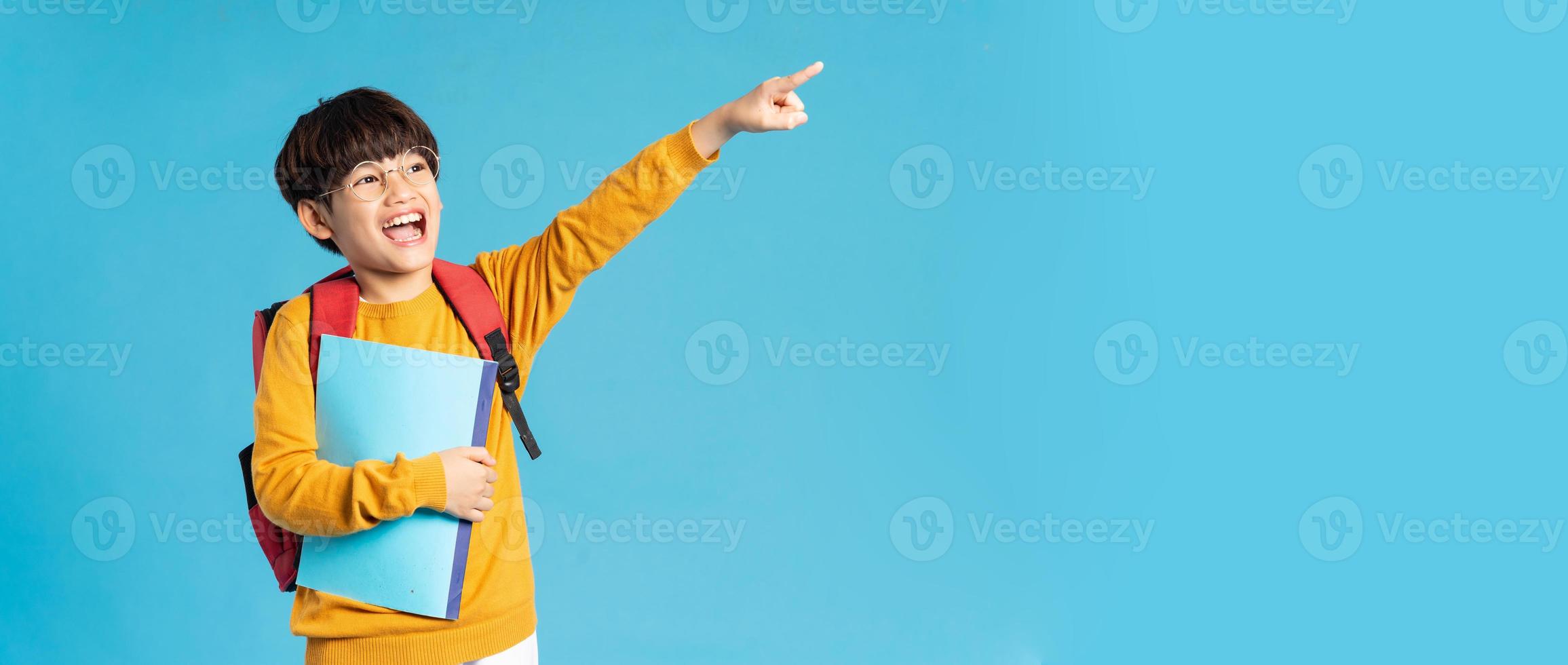 Portrait of Asian school boy born on a blue background photo