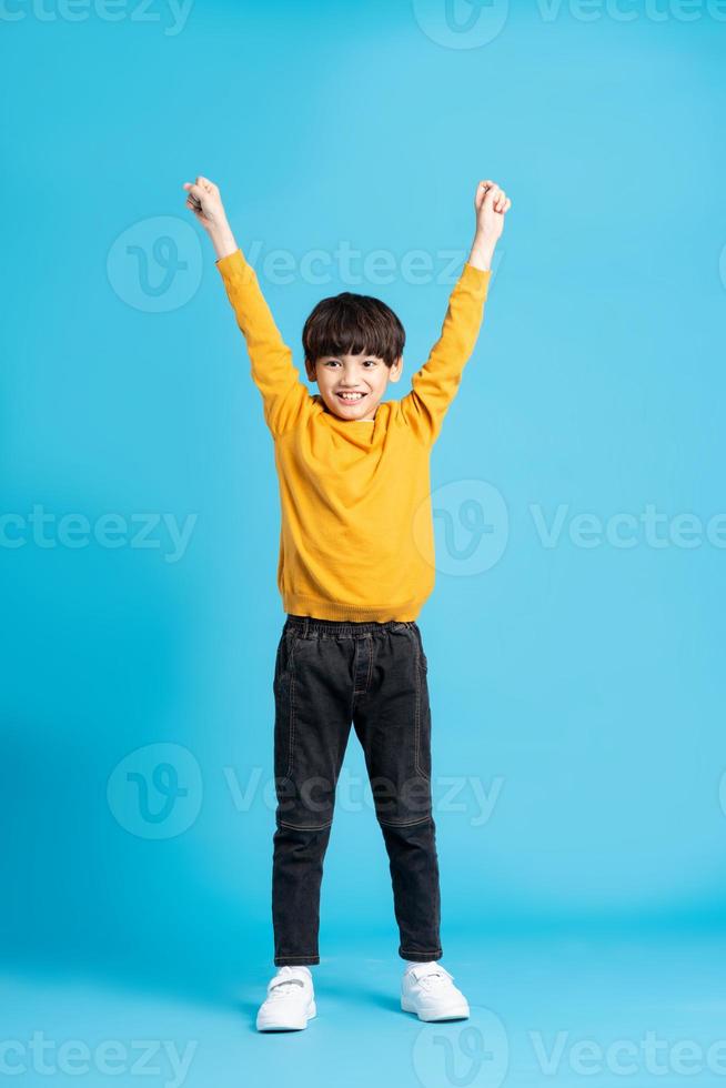 full body image of asian boy posing on blue background photo