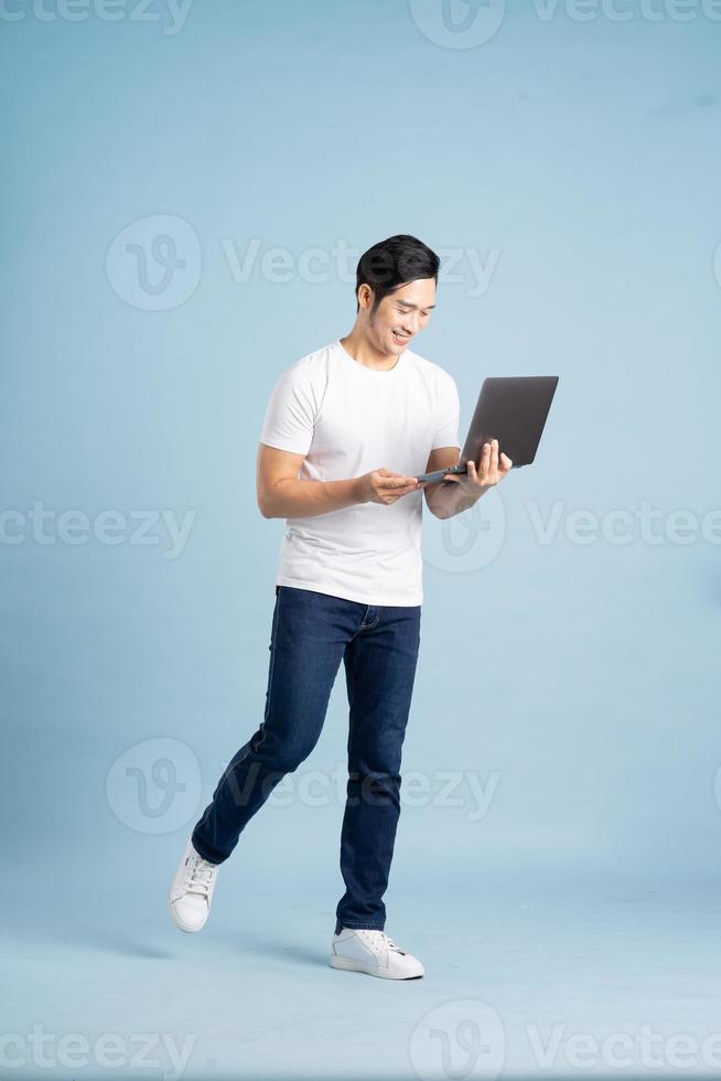 retrato de asiático hombre posando en azul antecedentes foto