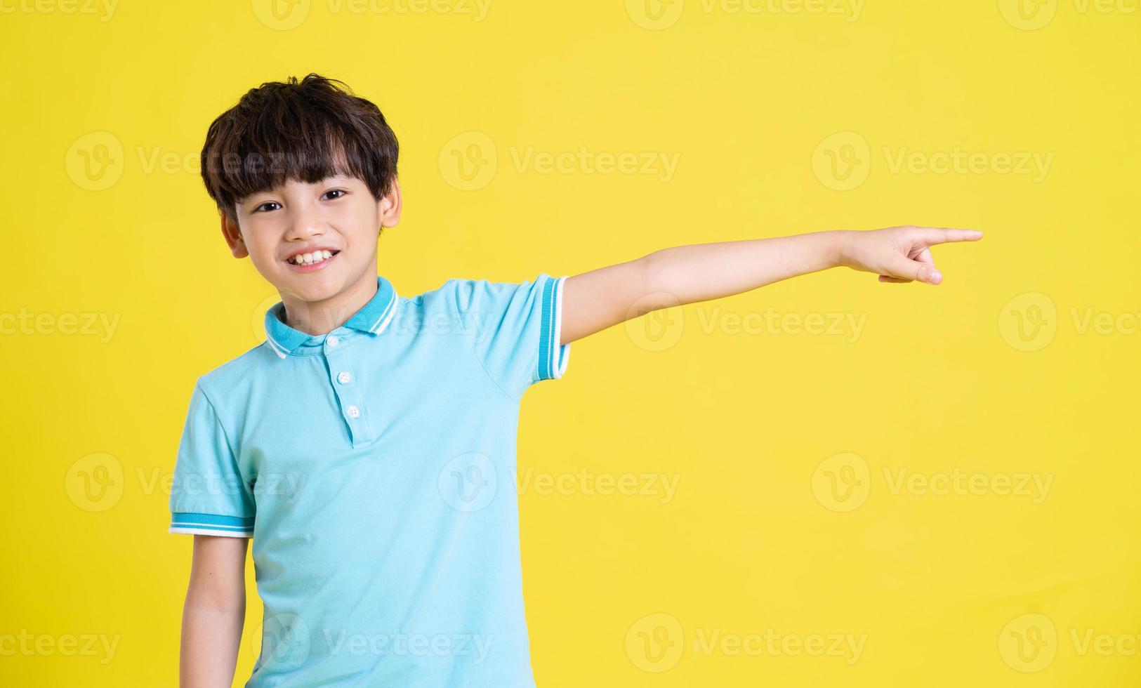 portrait of an asian boy posing on a yellow background photo
