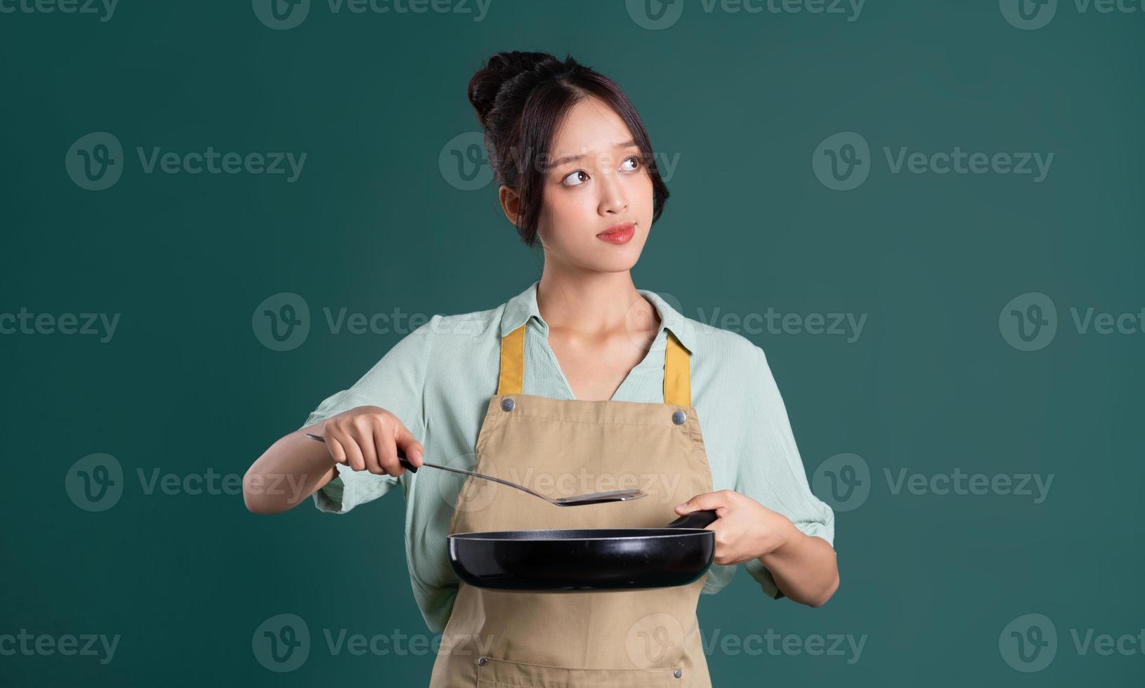 Asian woman wearing apron and holding a pan photo