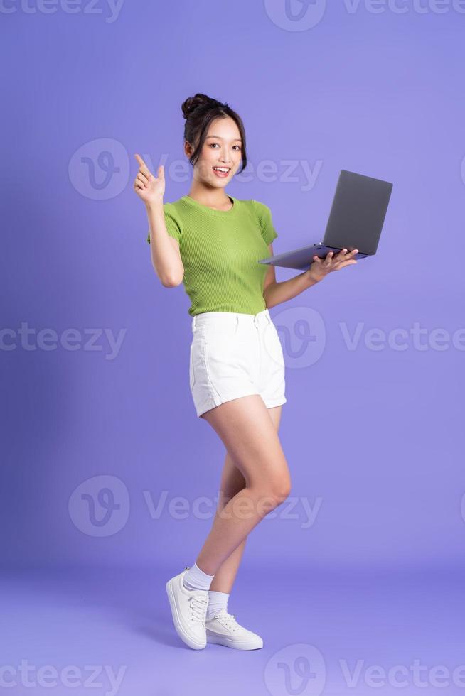 full body image of beautiful asian girl posing on pink background photo