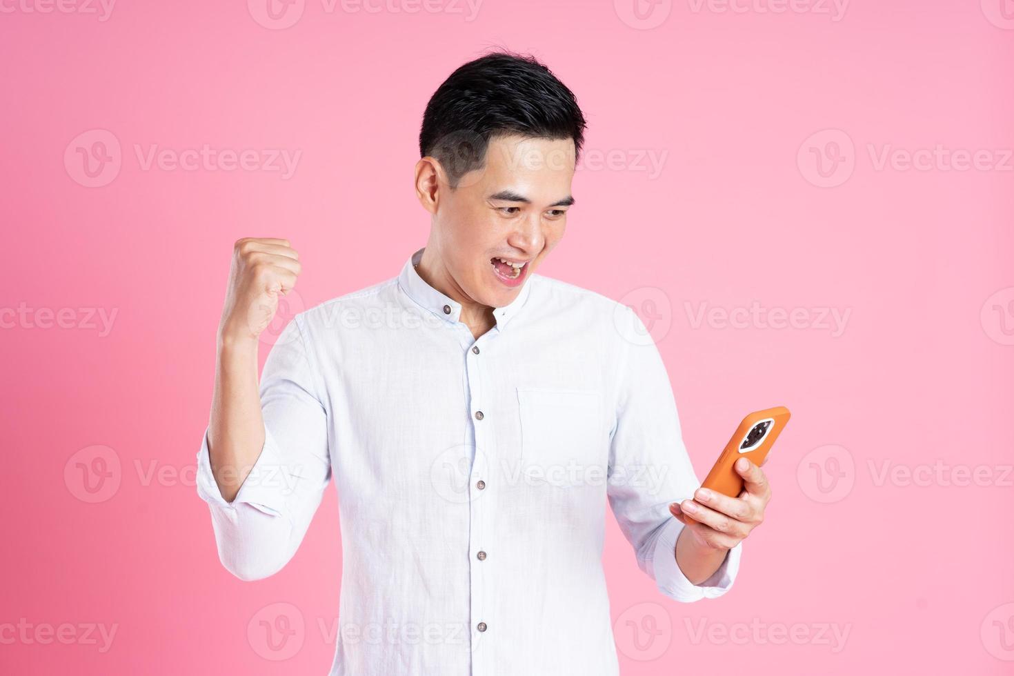 portrait of asian man posing on pink background photo
