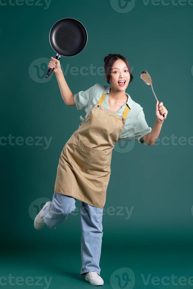 Asian woman wearing apron and holding a pan photo