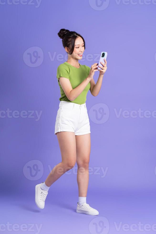 full body image of beautiful asian girl posing on pink background photo