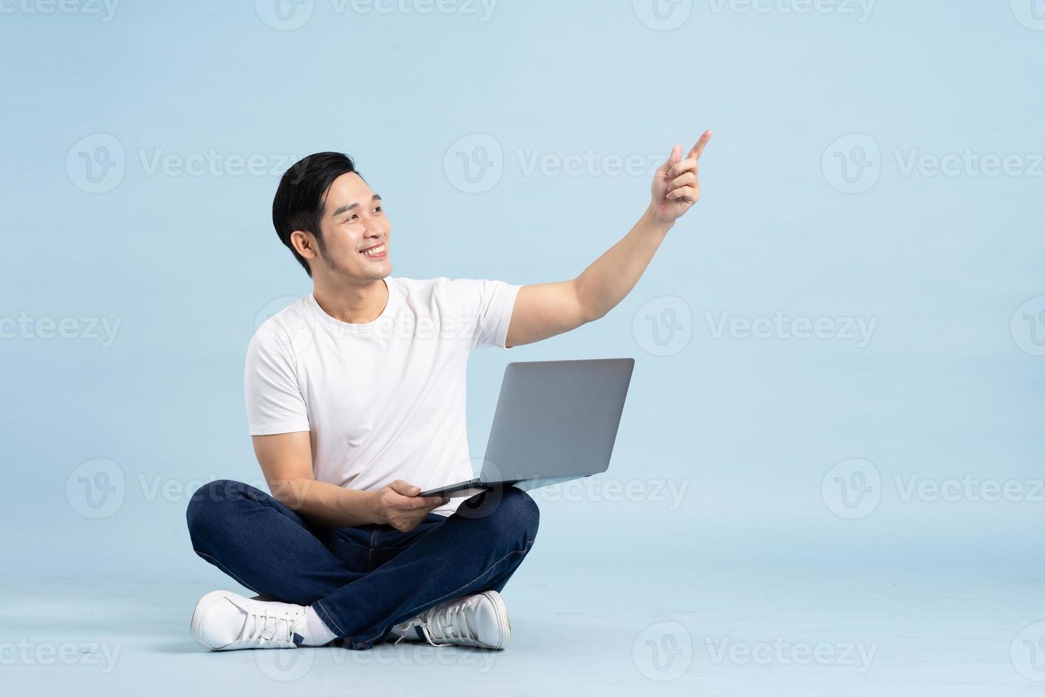 portrait of asian man posing on blue background photo