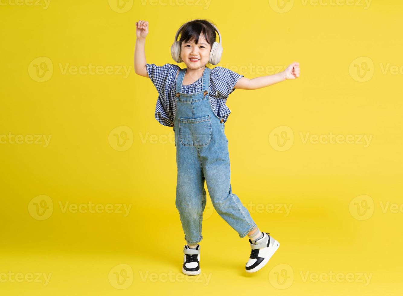 imagen de cuerpo completo de una hermosa niña asiática con fondo amarillo foto