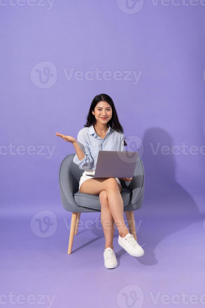 image of girl sitting on sofa  isolated on purple background photo