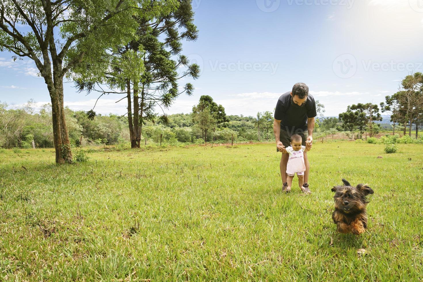 Baby girl in his first steps with her daddy. photo