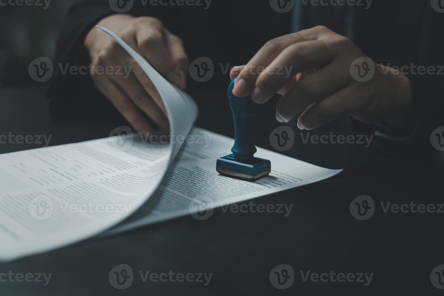 Man stamping approval of work finance banking or investment marketing documents on desk. photo