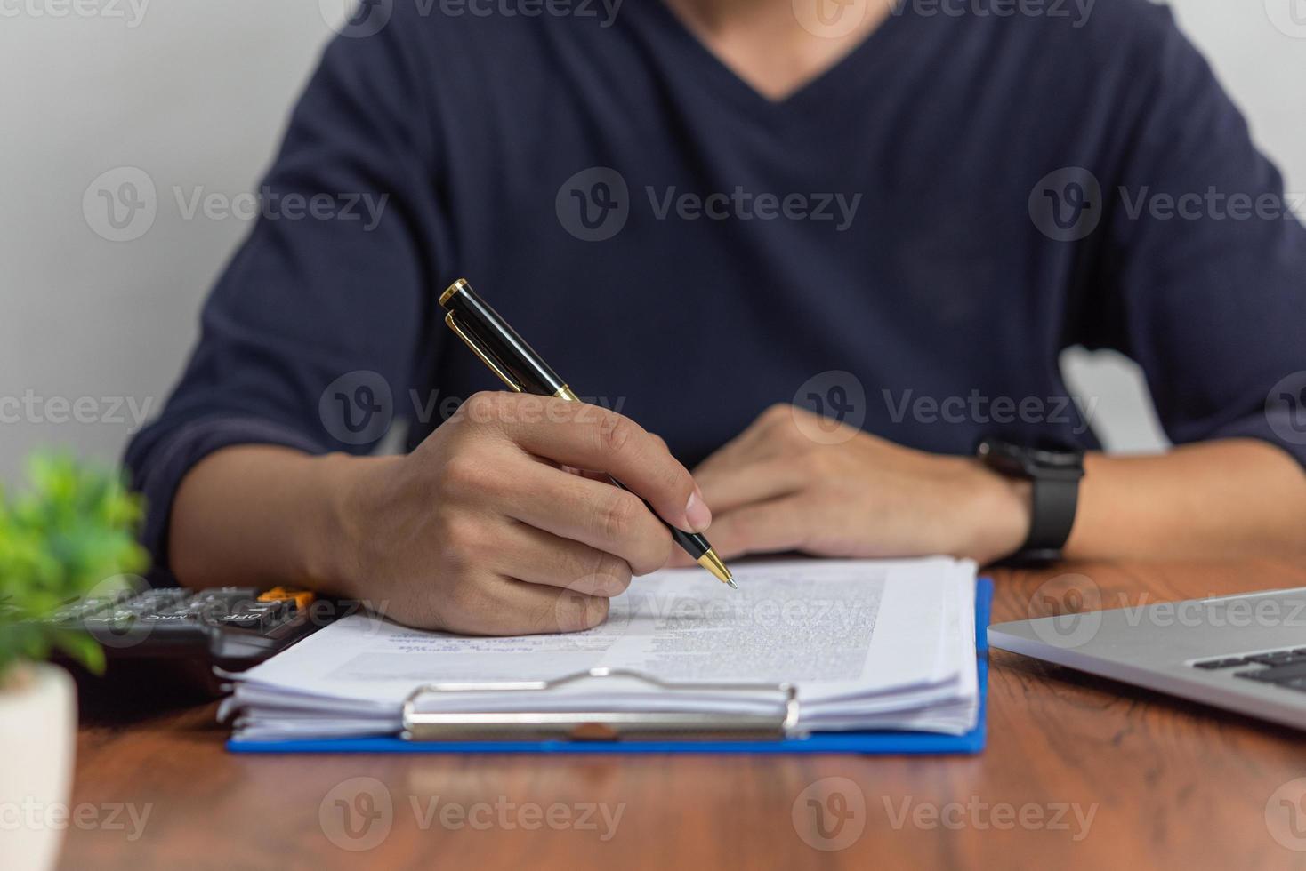 hombre de negocios que verifica la contabilidad de datos de documentos y el papeleo de finanzas fiscales o lee información legal. firma de contrato de informe comercial en el escritorio. foto