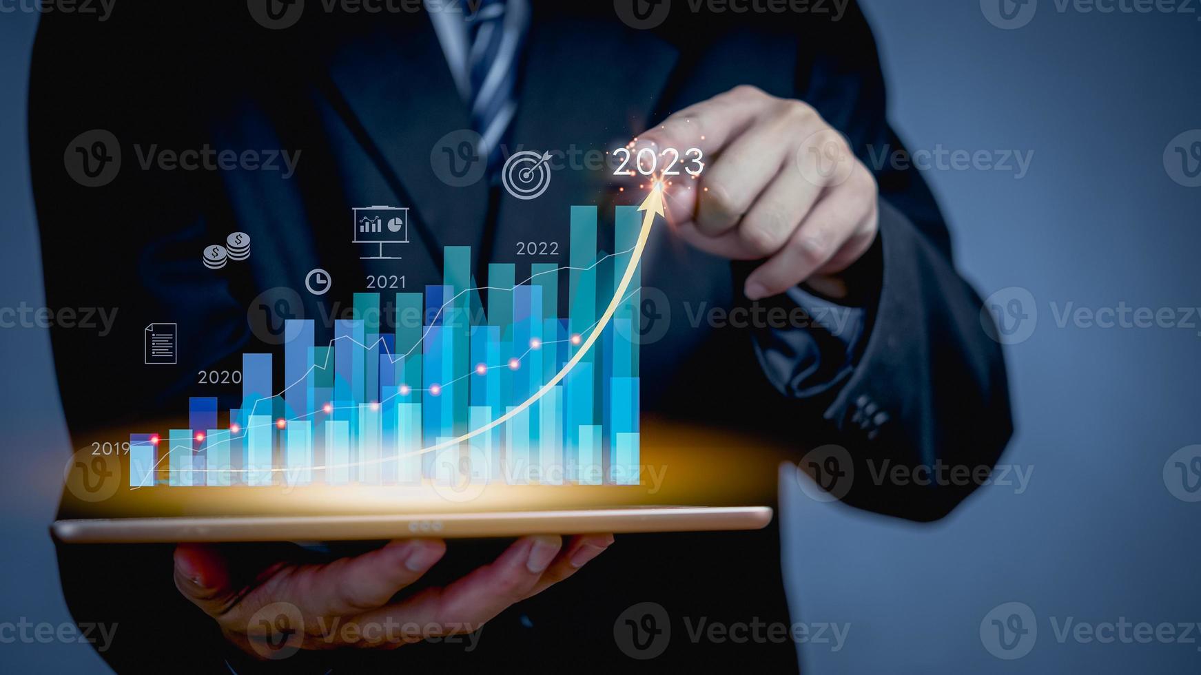 Businessman or trader is use tablet with growing virtual hologram stock graph, business financial data investment.planning and strategy, Stock market, Business growth 2023 concept. photo