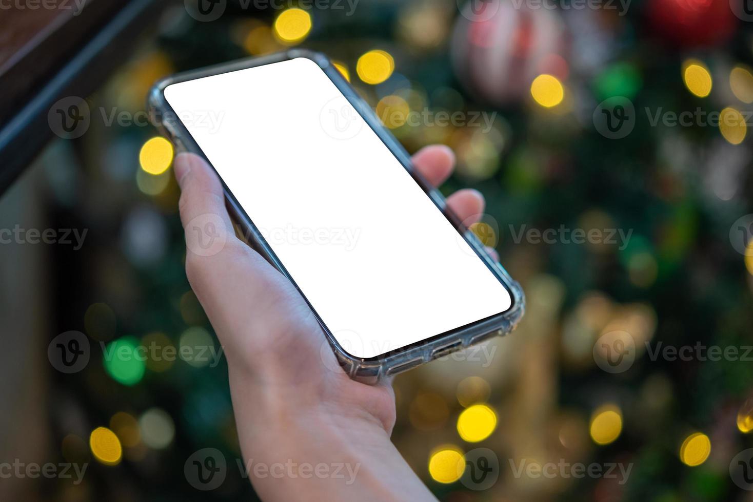 female hand holding and using a mobile phone mock up with bokeh background. searching or social networks concept. photo