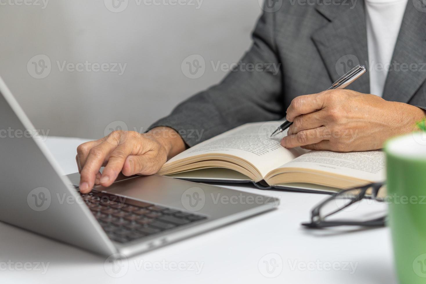 Woman hands with pen writing on notebook in the office.learning, education and work.writes goals, plans, make to do and wish list on desk. photo