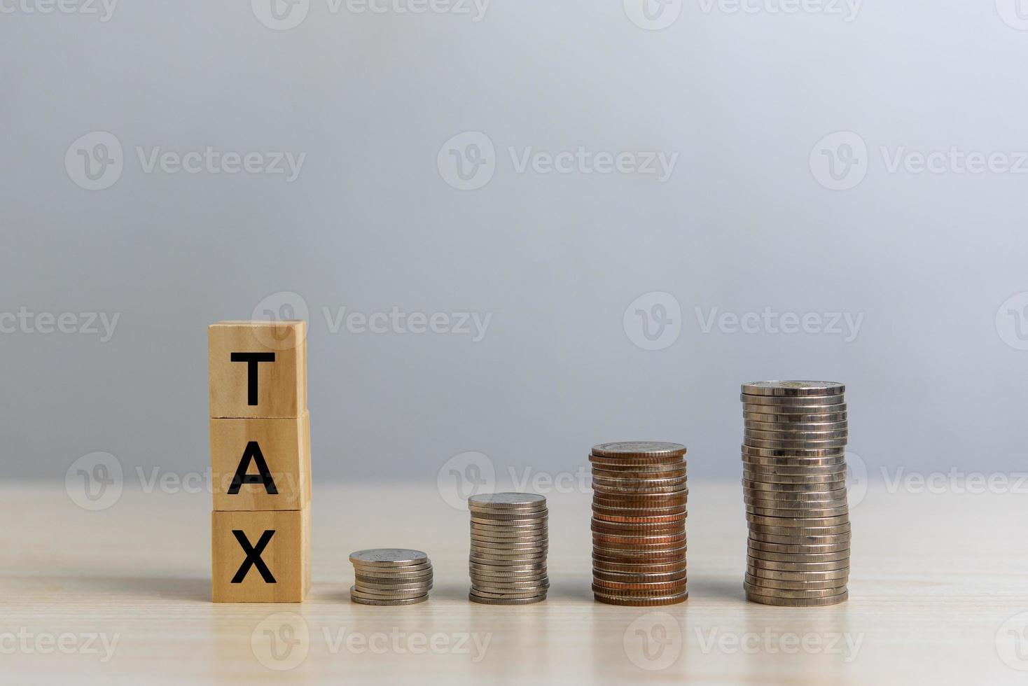 wood cube block TAX and coin money on desk. Business finance accounting income concept. photo