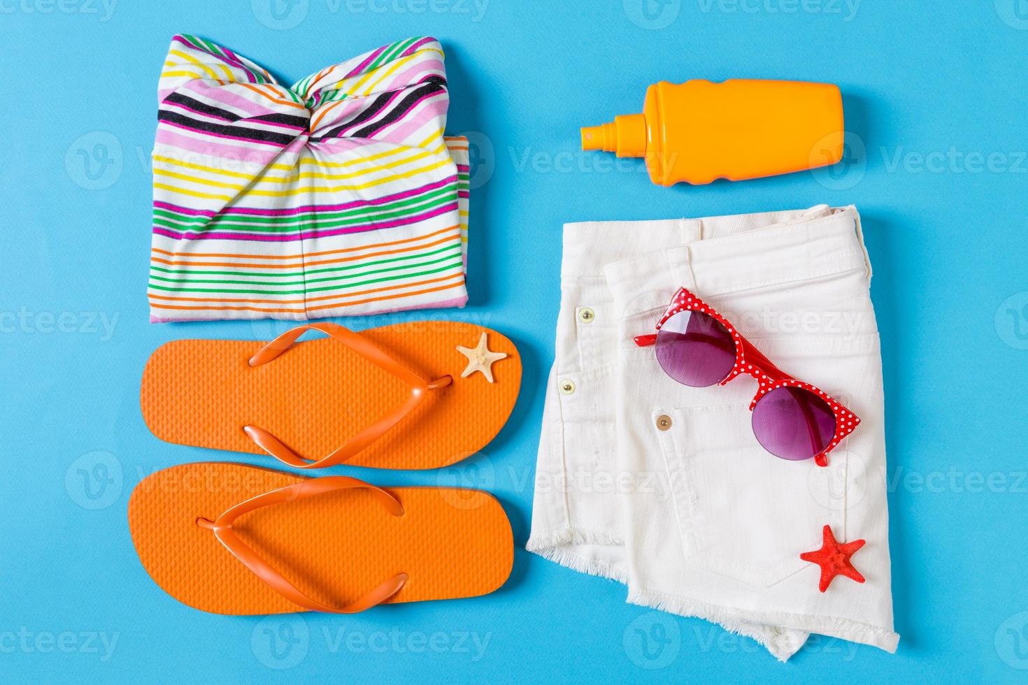 Flat lay composition with Beach accessories on blue color background. Summer holiday background. Vacation and travel items top view photo