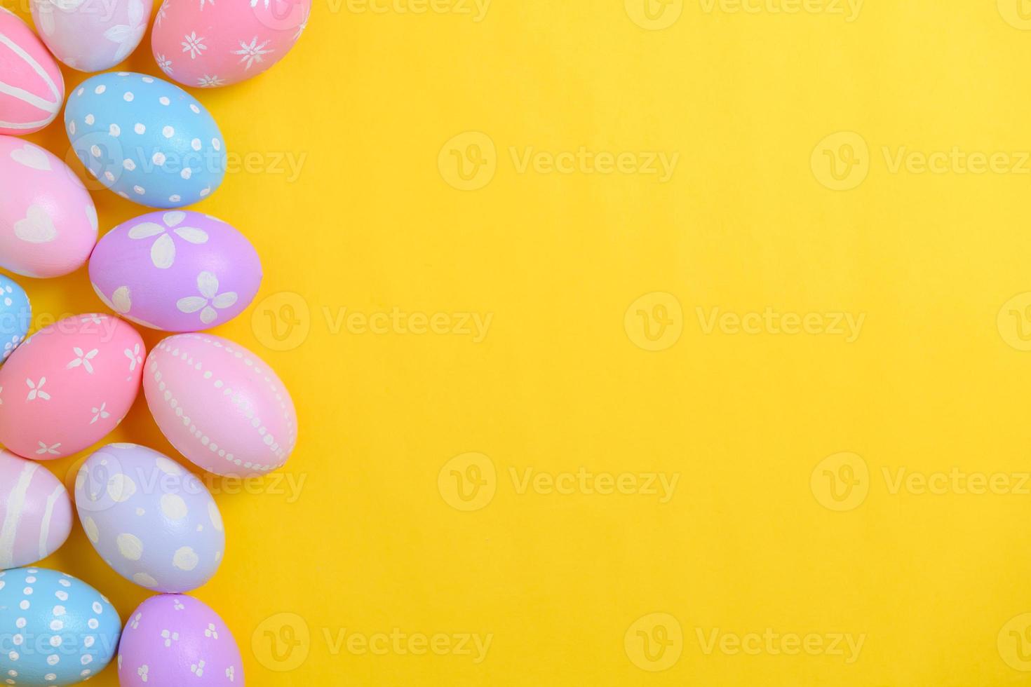 Happy easter holiday celebration concept. Group of painted colourful eggs decoration on a yellow background. Seasonal religion tradition design. Top view, flat lay, copy space. photo