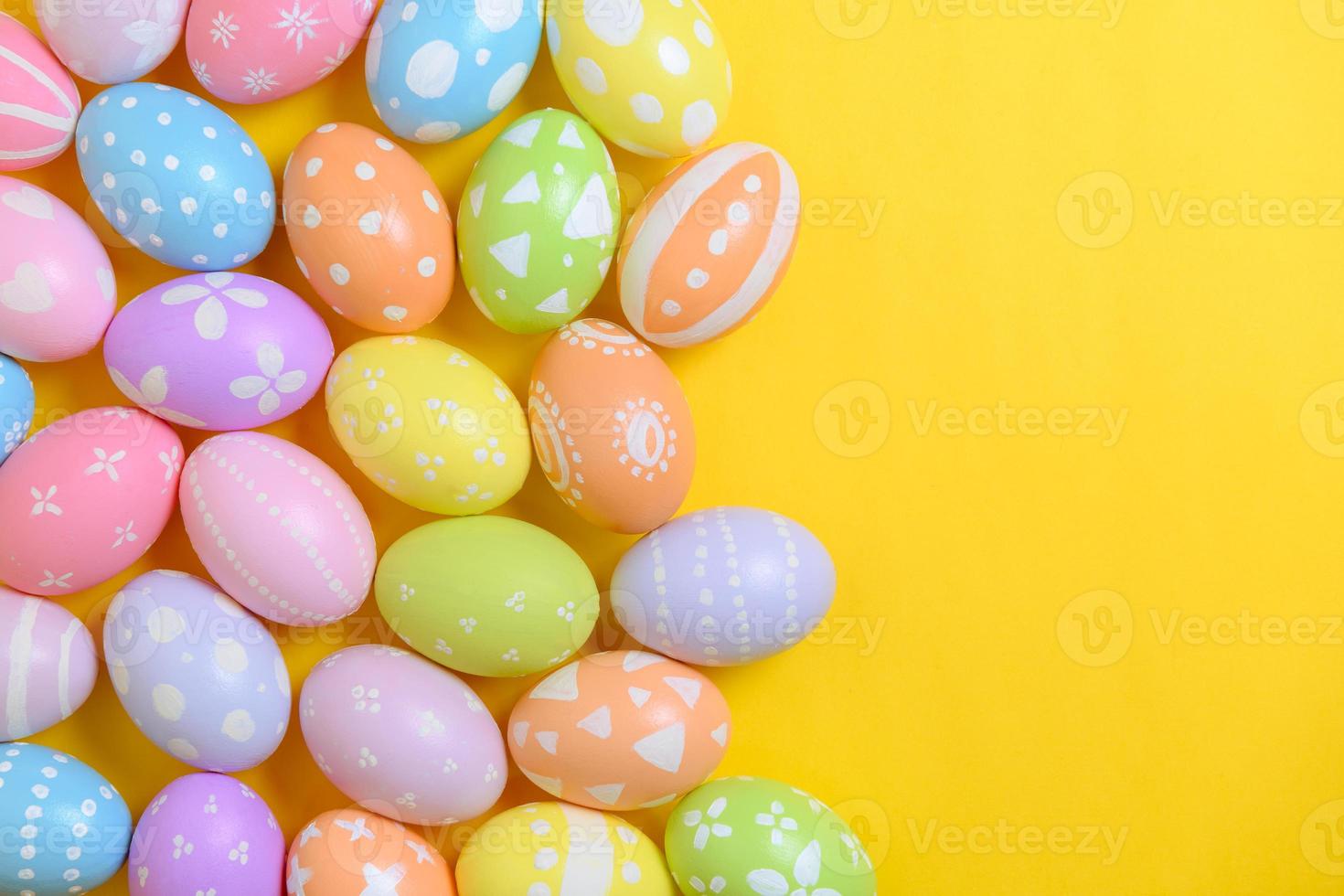 contento Pascua de Resurrección fiesta celebracion concepto. grupo de pintado vistoso huevos decoración en un amarillo antecedentes. estacional religión tradicion diseño. parte superior vista, plano poner, Copiar espacio. foto