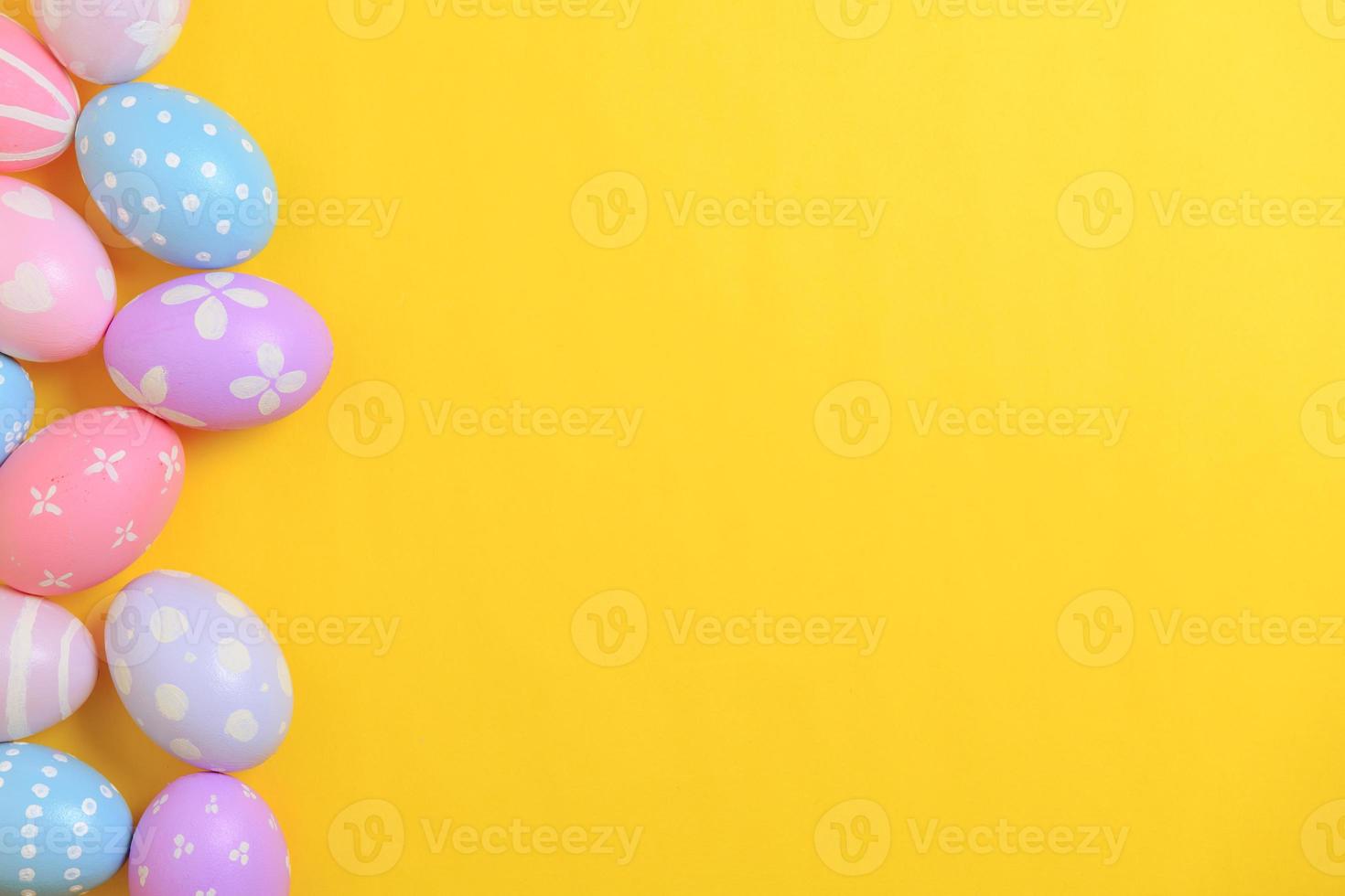 Happy easter holiday celebration concept. Group of painted colourful eggs decoration on a yellow background. Seasonal religion tradition design. Top view, flat lay, copy space. photo