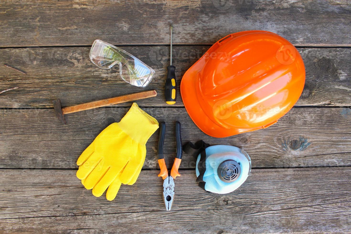 Construction tools and means of protection on an old wooden background. Top view, flat lay. photo