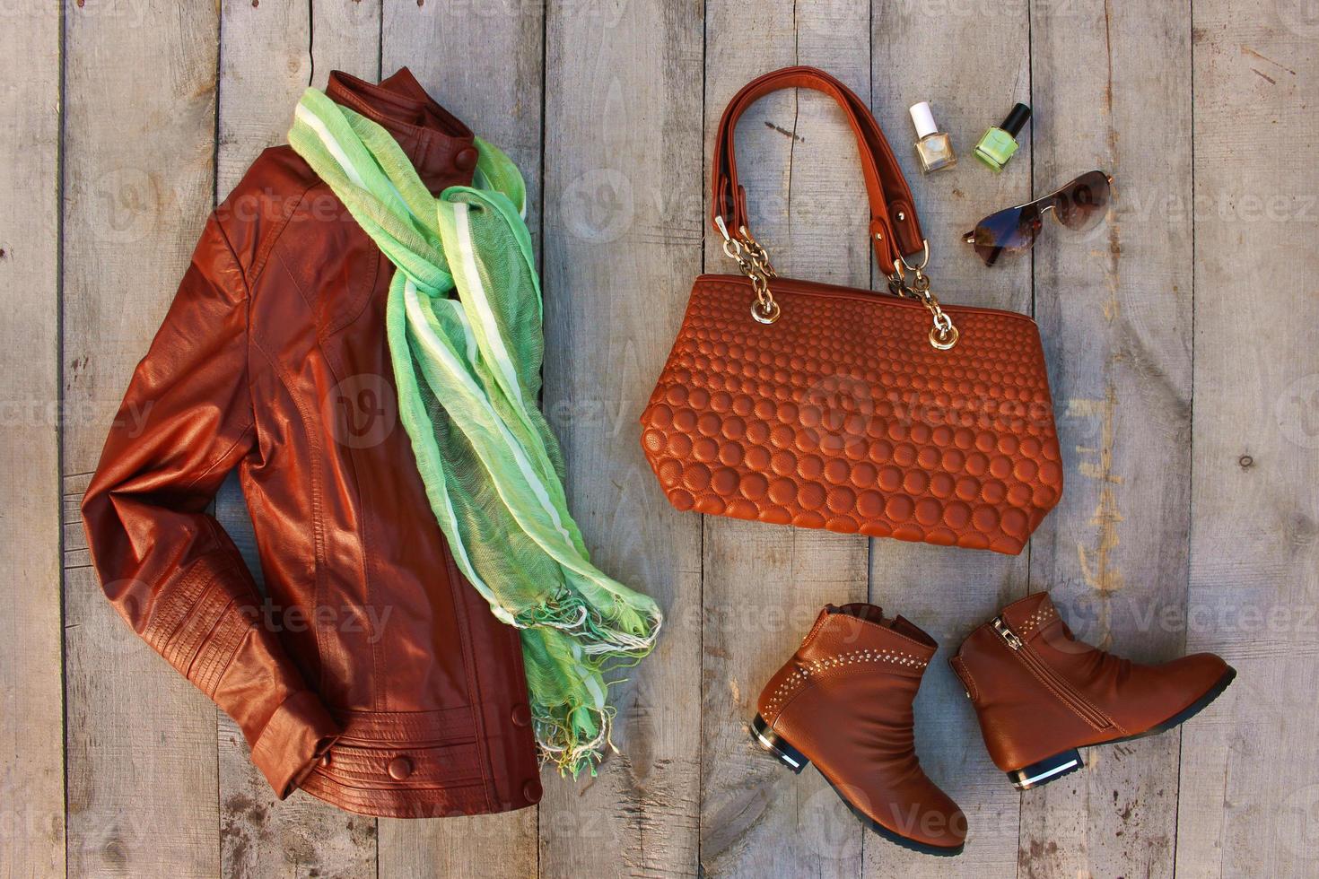 Women's clothing and accessories on old wooden background. Top view. Flat lay. photo