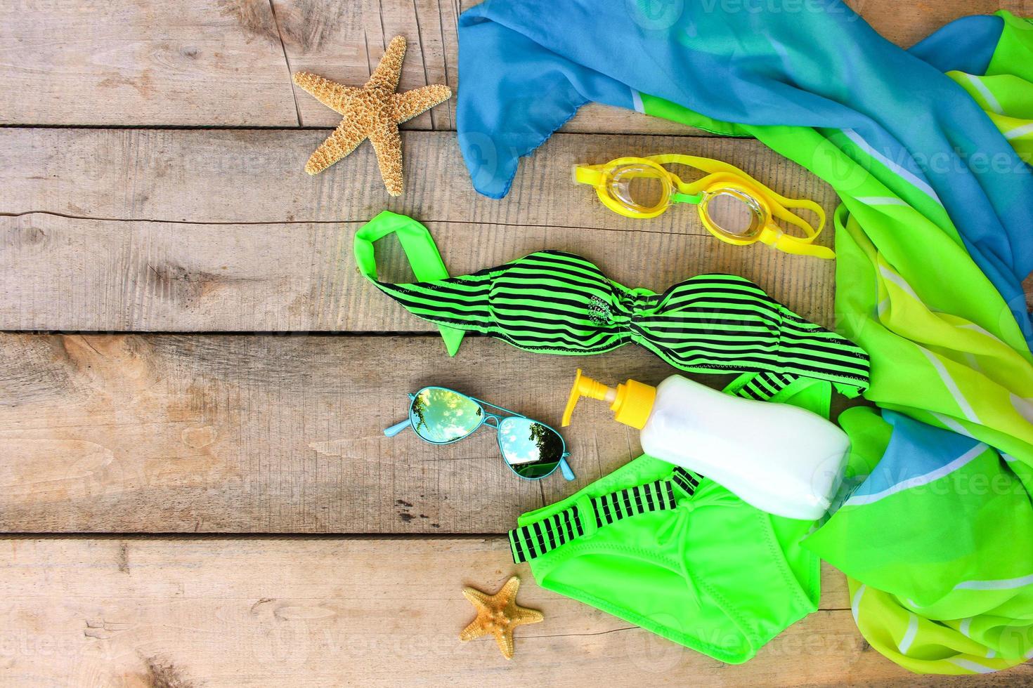 Summer women's clothing and accessories on the old wooden background. Top view. Flat lay. photo