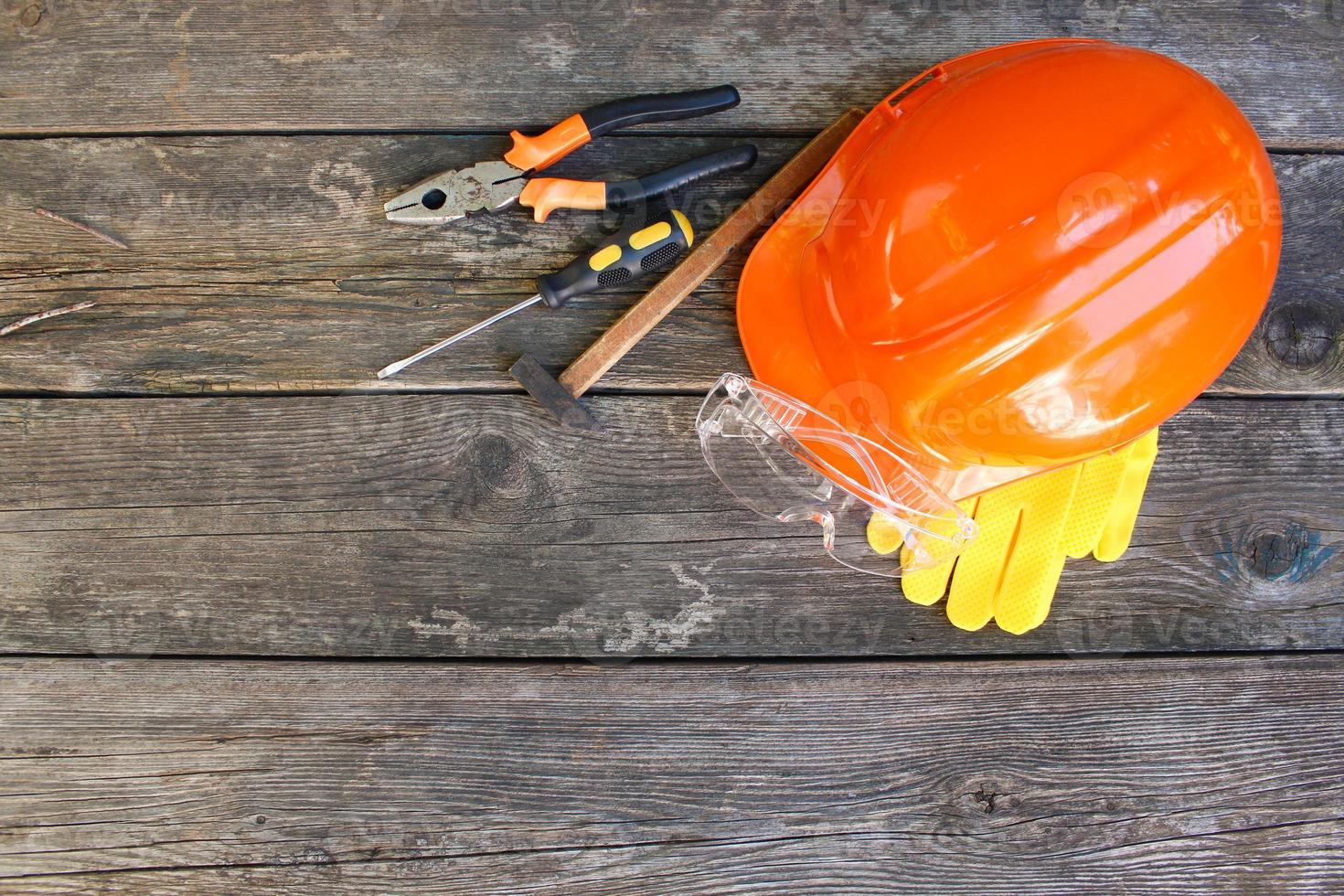 Construction tools and means of protection on an old wooden background. Top view, flat lay. photo