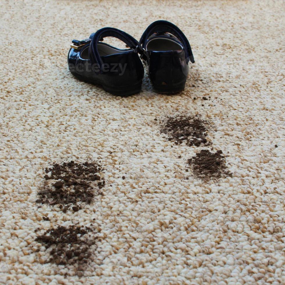 Dirty floor and children's shoes. Concept of child soiled carpet. photo