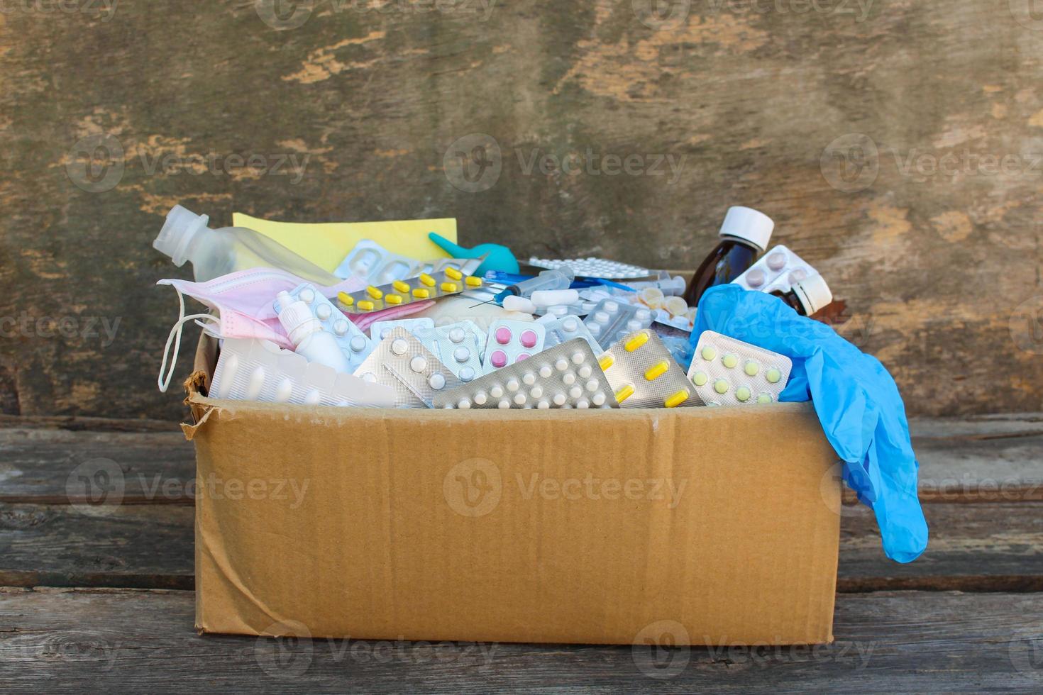 Box with medicines on old wooden background. photo